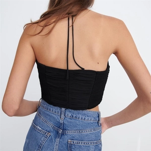 Close-up of the black halter neck top featuring detailed ruched back and open back design