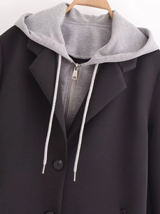 Detail of detachable grey knit hood and layered collar on a black tailored coat