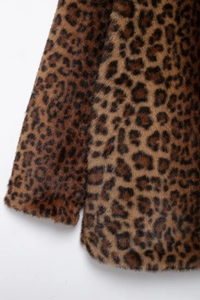 Detailed macro shot of leopard print faux fur texture and stitching on winter coat
