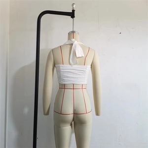 Detailed back view of white halter crop top with elastic ruched fabric texture