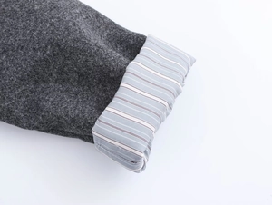 Detail of dark grey wool-like fabric with contrast striped lining and fine stitching