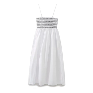 Detailed view of the smocked bodice and black geometric embroidery on white poplin dress