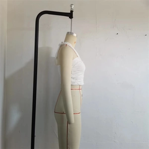 Side view of white textured wrap top with ring buckle on a beige mannequin