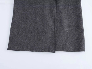 Detail of dark grey wool blend coat showing neat stitching and heavy fabric texture