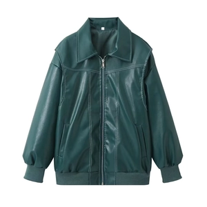 Détail d'une veste en similicuir vert foncé avec surpiqûres blanches et zip métallique