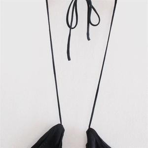 Close-up of black U-shaped halter neck top with slim adjustable tie straps and soft texture