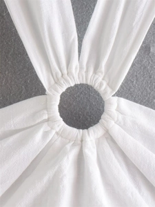 Detail view of white cotton linen top featuring a central ring with pleated fabric texture