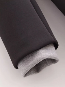 Detailed close-up of double-layered sleeve with black plain fabric and grey ribbed knit cuff