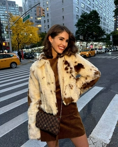 Look urbain d'une femme en veste en fausse fourrure motif vache et robe velours
