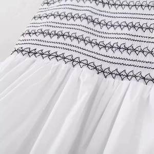 White poplin dress featuring black zigzag embroidery on smocked elastic waist detail