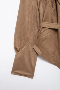 Detail of brown faux suede jacket featuring waist belt, pockets, and premium stitching
