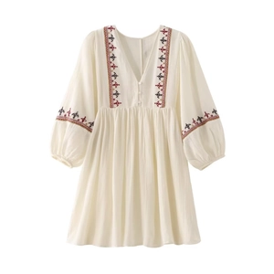 Detail of bohemian ivory cotton dress with ethnic geometric embroidery on sleeves