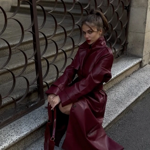 Deep burgundy long faux leather trench coat with waist belt and classic lapel collar