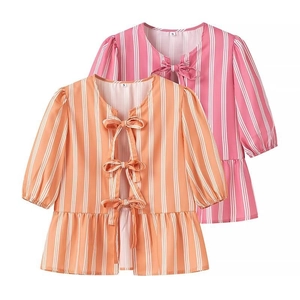 Detail of pink and orange striped shirts featuring bow tie closures and peplum hems