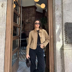 Women's khaki suede cropped jacket with large utility pockets and black buttons outdoors