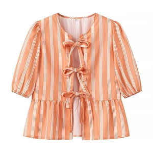Detail of summer short-sleeved top featuring orange vertical stripes and bow-tie closures