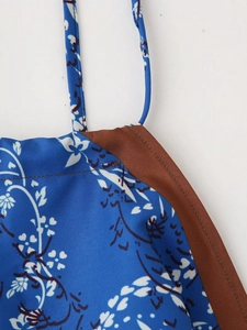 Dettaglio macro del top estivo blu a fiori con bordo in raso marrone e spalline