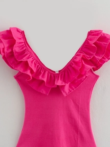 Detail of rose pink ribbed knit jumpsuit featuring deep V-neck and ruffled edge design