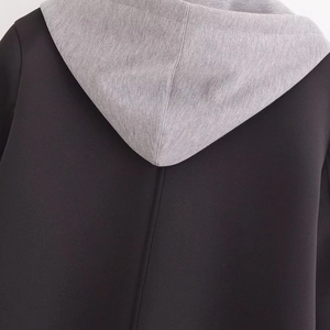Modern women's black coat with a detachable grey marl hood and minimalist design