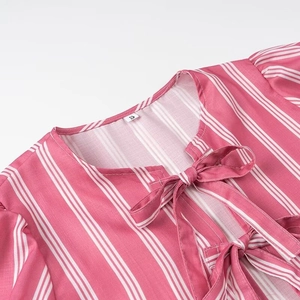 Detail of pink vertical stripes and delicate bow ties on a women's summer shirt neckline