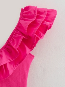 Detail showing ruffled shoulder and ribbed fabric texture of fuchsia romper jumpsuit