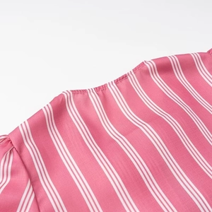 Close-up detail of the fine stitching and pink vertical striped fabric of this shirt