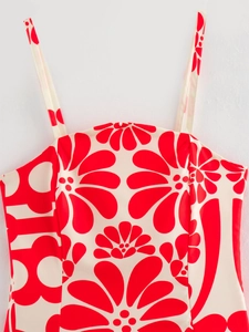 Close-up of fine straps and red floral print on an ivory summer maxi dress