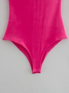 Close-up of magenta ruffled bodysuit featuring a snap closure at the bottom hem