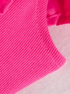Detailed macro view of the ribbed knit fabric texture and sewing on the fuchsia jumpsuit