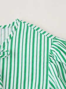 Détail du haut rayé vert et blanc en coton-lin avec coutures sur les manches bouffantes