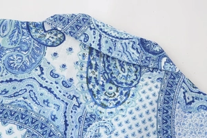Detailed macro view of the blue paisley print fabric and high-quality stitching on the shirt