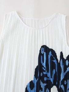Detail of white pleated sleeveless top featuring vibrant blue butterfly print and round neck