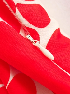 Detail of red and white polka dot dress featuring a seamless concealed zipper closure