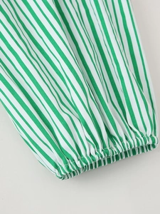 Détail de tissu à rayures verticales vertes et blanches avec poignets élastiques froncés