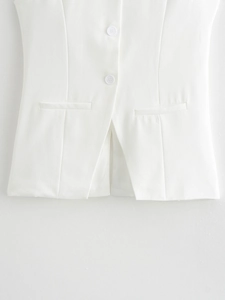 Detail of white vest buttons with welt pockets and refined stitching on suit fabric