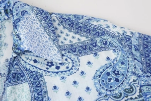 Close-up detail of blue and white paisley print on high-quality shirt collar fabric