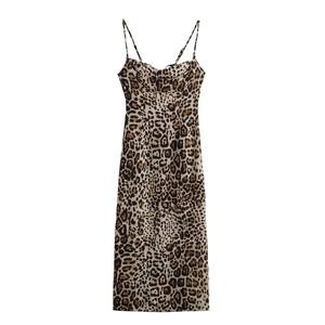 Détail de robe midi léopard avec fines bretelles réglables sur fond blanc impeccable