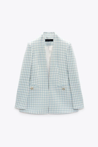Detail of blue houndstooth blazer showing golden pearl buttons and woven texture