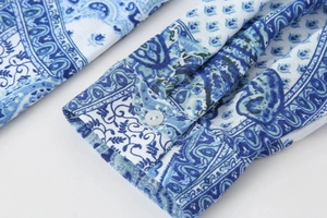Detailed macro view of the sleeve cuff with paisley print and a white round button