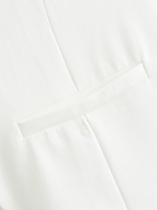 Close-up of premium white woven fabric detail showing refined welt pocket and stitching