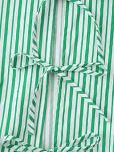 Détail du tissu à rayures vertes et blanches avec un nœud décoratif assorti sur le haut