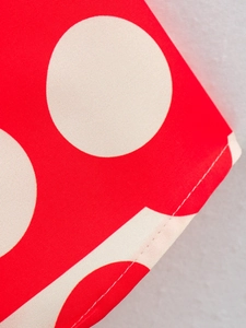 Detail of red white polka dot fabric with twill texture and single needle stitching