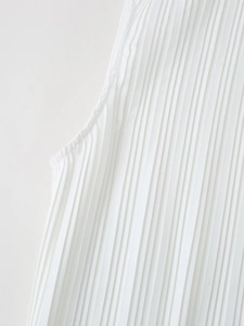 Macro shot of fine accordion pleat texture and neat stitching on a white dress