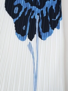 Detailed close-up of pleated white fabric with elegant blue floral print patterns