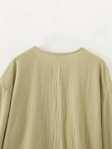 Vue détaillée du dos d'un haut en lin vert clair montrant les coutures et la texture du tissu