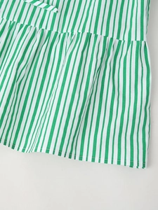 Détail d'un haut rayé vert et blanc avec tissu plissé et cordon de serrage fin ajustable