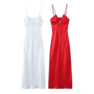 Flat lay of white and red satin midi dresses with ruffle necklines and bow detail