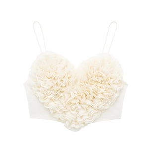 Détail d'un caraco blanc crème avec froufrous en forme de cœur 3D et fines bretelles