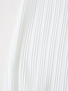 Close-up of elegant pleated texture on a white summer dress with fine vertical folds