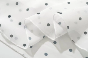 Dettaglio del tessuto bianco a pois con cuciture di alta qualità sul bordo
